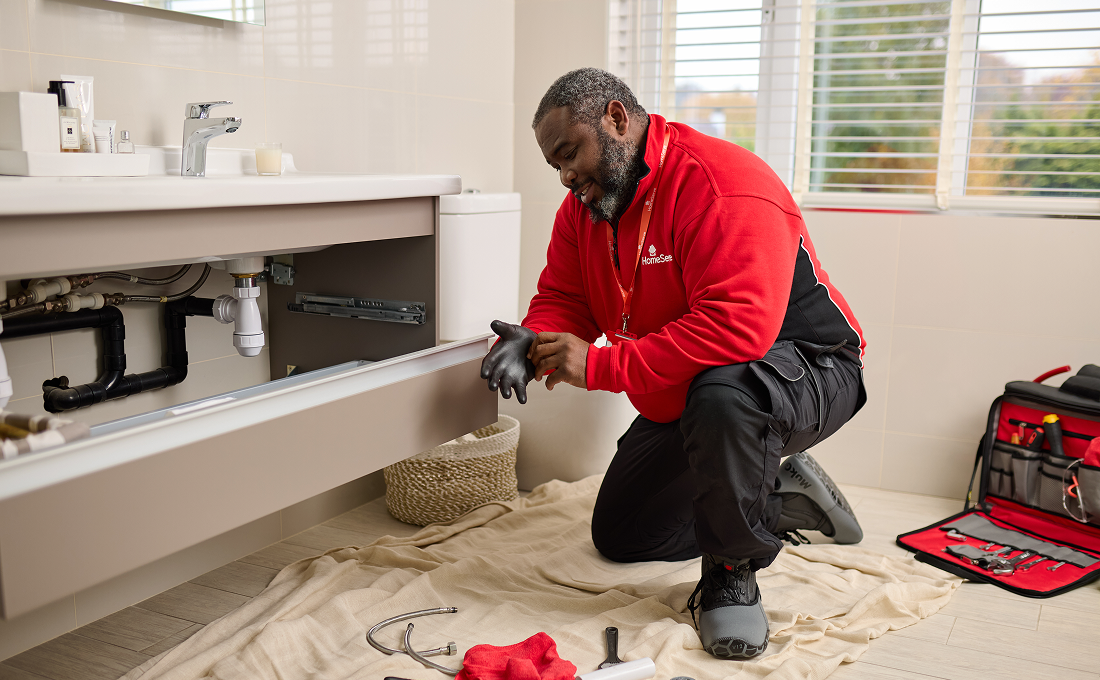 HomeServe engineer fixing plumbing issue under sink HomeServe engineer fixing plumbing issue under sink